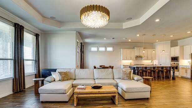 A spacious living room with a large sectional sofa, a wooden coffee table, and a chandelier. - < 20 Mi to Fort Worth: Family-Friendly Aledo Home (Aledo)
