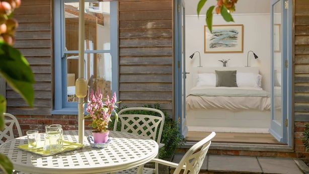 A cozy outdoor seating area with a table, chairs, and a potted plant.