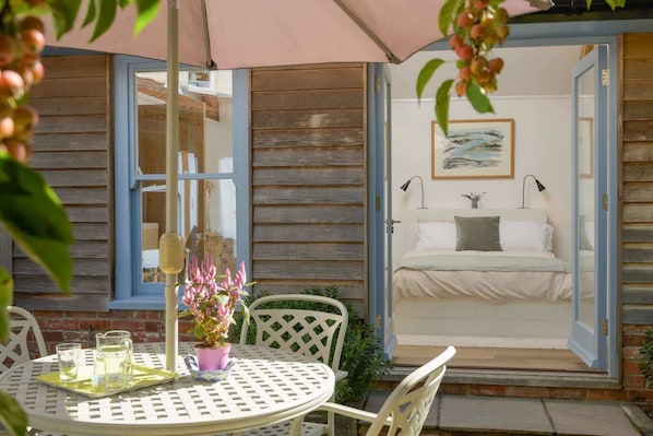 A cozy outdoor seating area with a table, chairs, and a potted plant.