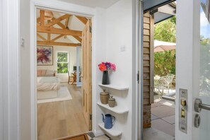 Une pièce comprenant un lit, un bureau et une chaise. Il y a une fenêtre donnant sur un paysage verdoyant.