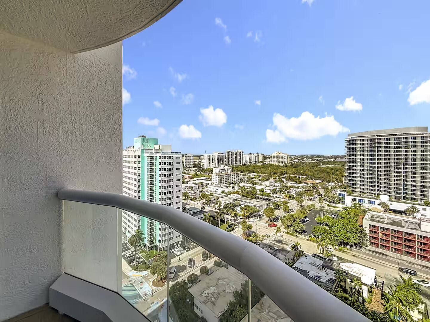 A high-rise building with a view of a cityscape, including various buildings and a clear sky.