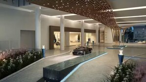 A modern hotel lobby with a car entrance, a water feature, and a large, open space with columns. - Luxury Suites at Fort Lauderdale Beach (Fort Lauderdale)