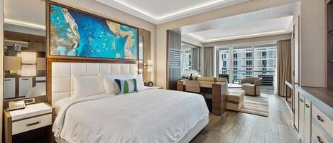 A modern hotel room with a large bed, a desk, a chair, and a view of the city.