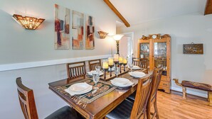 A dining room with a wooden table set for six, surrounded by chairs. There are wall-mounted light fixtures and a mirror cabinet. - Wine & BBQ Trail Fun: Home w/ Hot Tub in Lexington (Lexington)