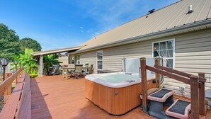 A wooden deck with a hot tub, outdoor furniture, and a covered patio area. - Wine & BBQ Trail Fun: Home w/ Hot Tub in Lexington (Lexington)