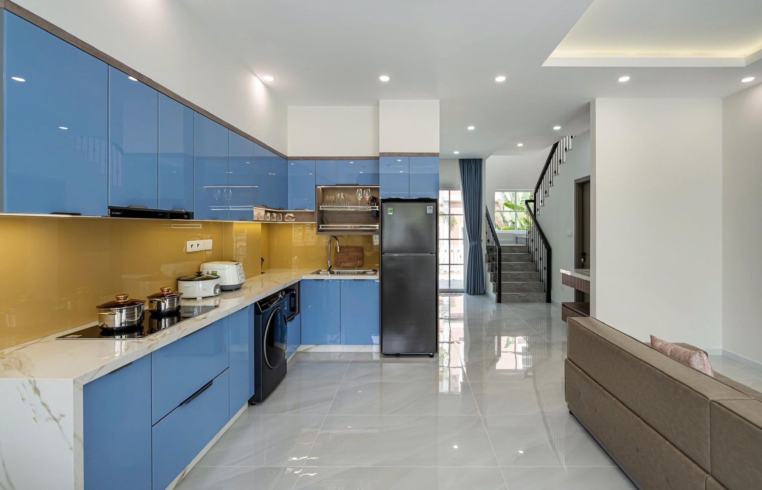 Una cocina moderna con armarios azules, un refrigerador de acero inoxidable y un horno empotrado.