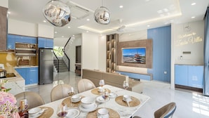 Una cocina moderna con armarios azules, horno empotrado y refrigerador de acero inoxidable.