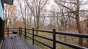 A wooden deck with a grill, surrounded by trees and a view of the forest. - rinne 2nd living Nasu Creek (Nasu)