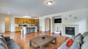 A spacious living room with a wooden coffee table, grey sofas, and a fireplace. - 7 Mi to Lake Yosemite: Family Home w/ Fenced Yard (Merced)