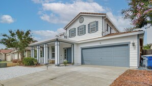 A two-story house with a garage, a covered porch, and a driveway. - 7 Mi to Lake Yosemite: Family Home w/ Fenced Yard (Merced)
