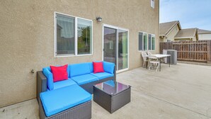 An outdoor patio with a blue sectional sofa, a glass-top coffee table, and a white table and chairs. - 7 Mi to Lake Yosemite: Family Home w/ Fenced Yard (Merced)