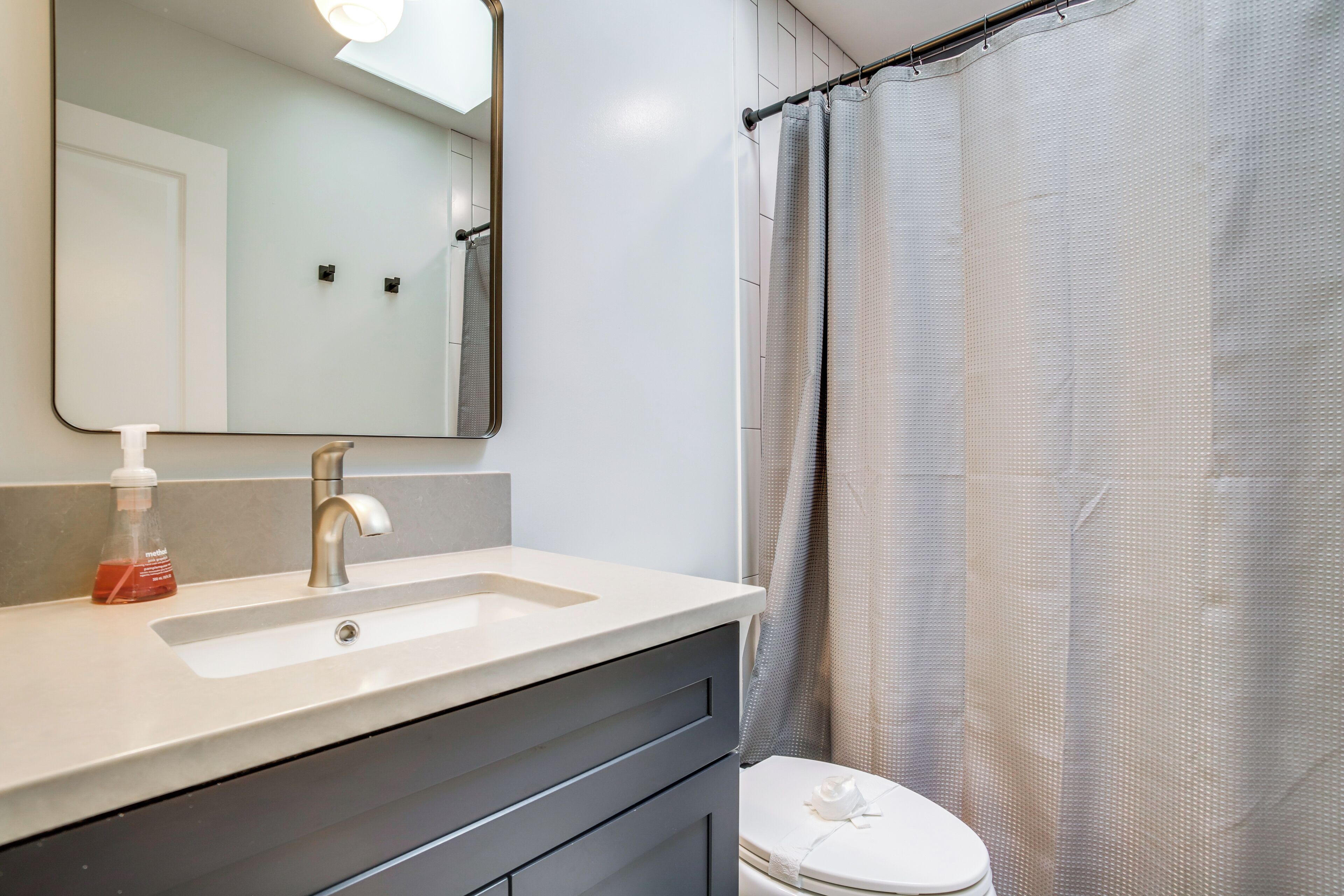 Ein Badezimmer mit Waschbecken, Spiegel und Toilette.
