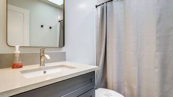 Ein Badezimmer mit Waschbecken, Spiegel und Toilette.