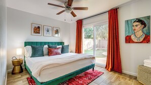 A bedroom with a bed, a ceiling fan, a nightstand, a window with curtains, and artwork on the wall. - Easy Walk to Dtwn Gilbert, Family-Friendly Oasis! (Gilbert)