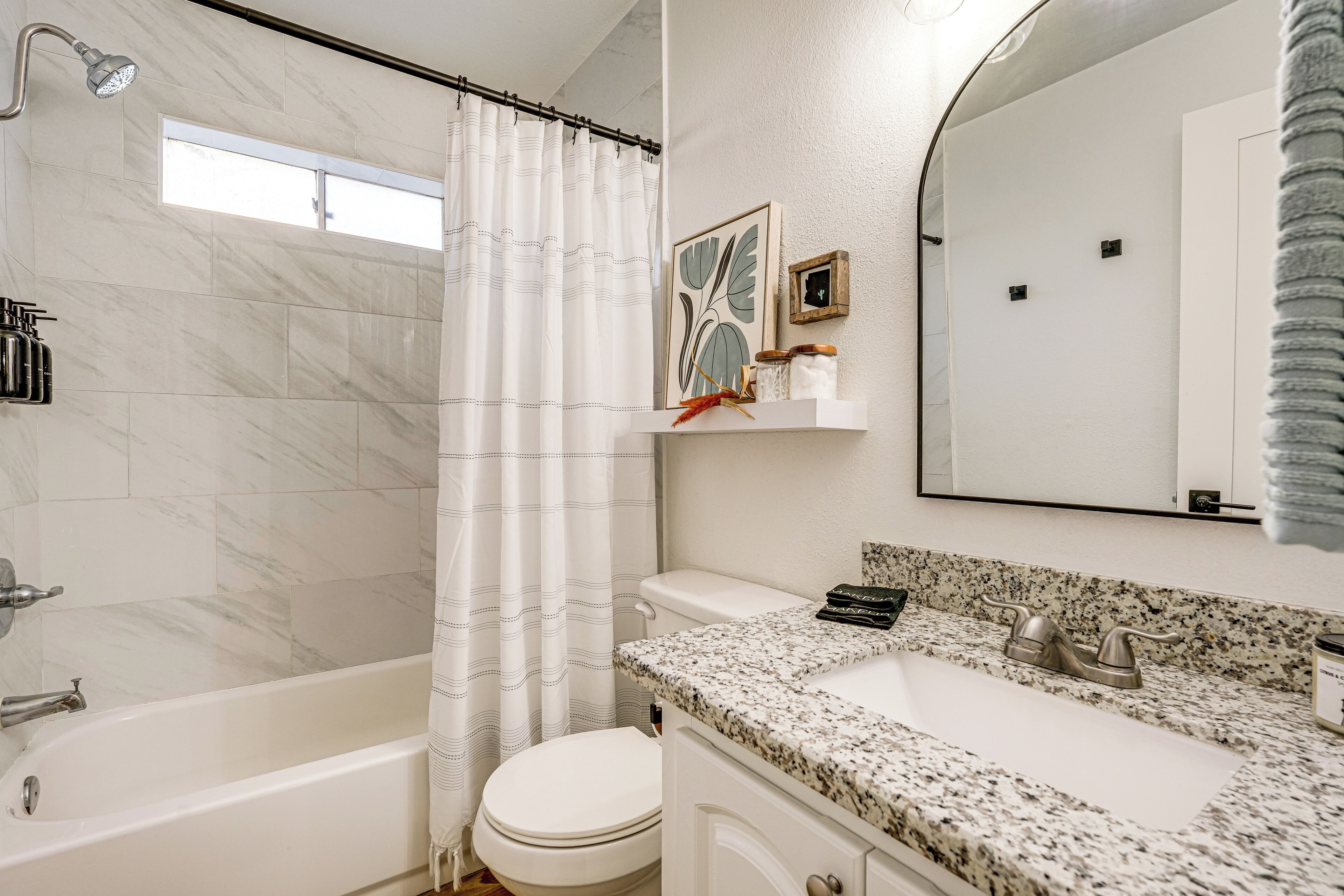 A bathroom with a bathtub, toilet, and sink.