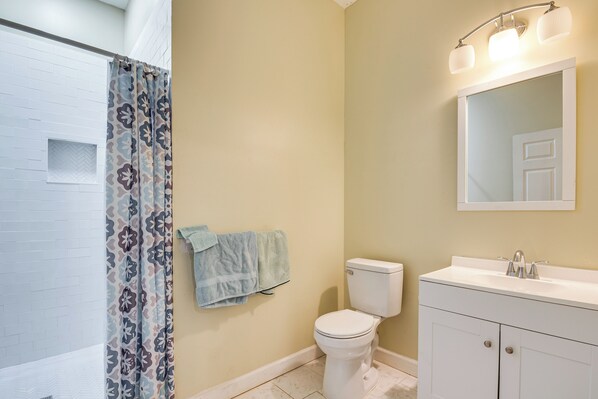 Une salle de bain équipée d’une douche, de toilettes, d’un lavabo et d’un miroir.