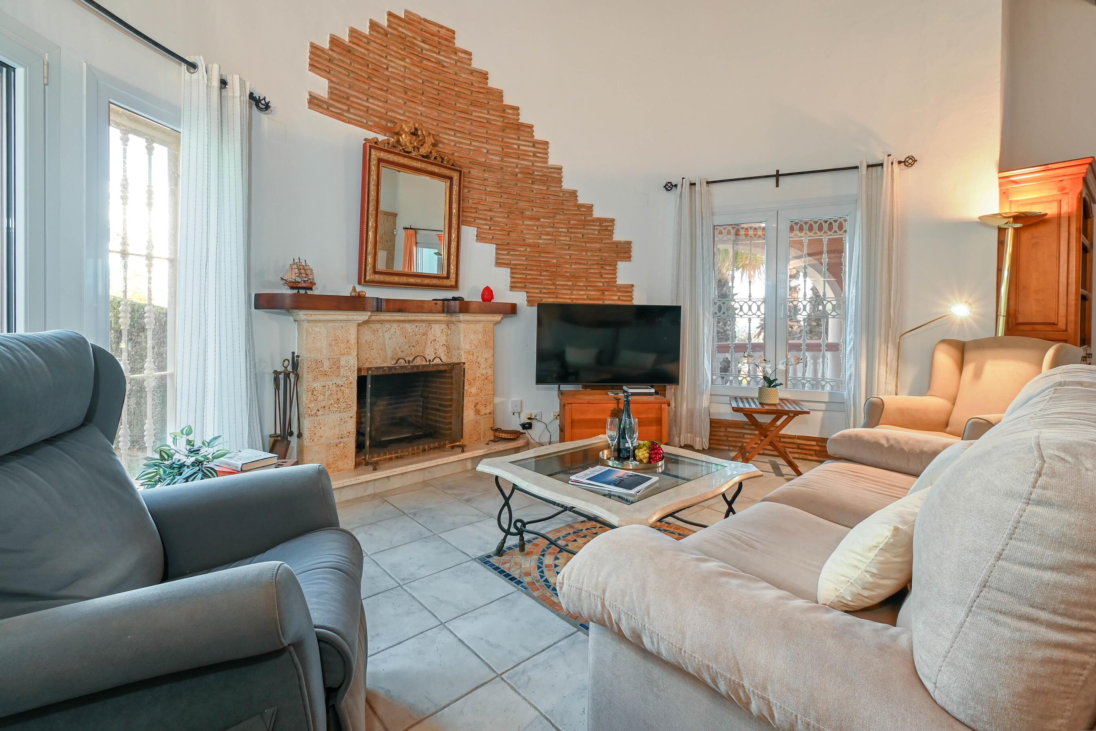 A living room with a fireplace, a television, and comfortable seating.