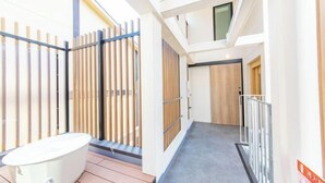 Un intérieur moderne avec une baignoire, des lambris en bois et un couloir menant à une porte.