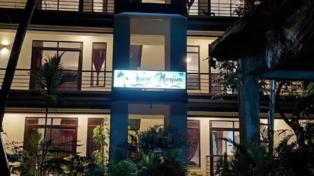Um hotel de vários andares com uma placa que diz 'Have a Good Time'.