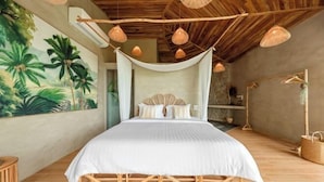 A spacious bedroom with a large bed, a hammock, and a mural of tropical foliage on the wall. - Carbana Lodge, 2 Bedrooms - Eco Lodge, Koh Samui (Koh Samui)