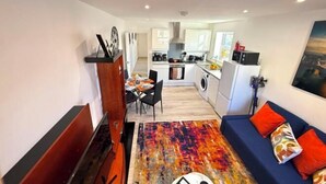Ein modernes Wohnzimmer mit einer Couch, einem Couchtisch und einem Essbereich mit Stühlen und einem Tisch.