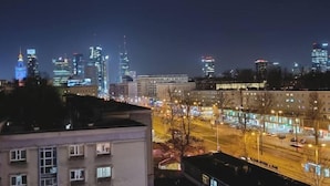 A nighttime cityscape with illuminated buildings and a well-lit street. - Nowolipki Studio, City Center Skyline View, WarsawStay (Warsaw)