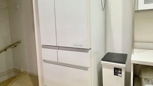 A room with a white wardrobe, a small black appliance, and a white shelf unit. - Skytree Urban House (Tokyo)