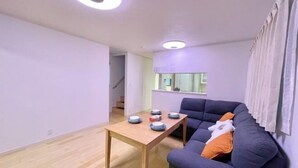A modern living room with a sofa, a table with bowls, and a window. - Skytree Urban House (Tokyo)