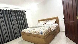 Une chambre à coucher avec un lit, des rideaux et une porte.