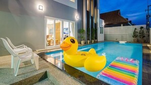 A swimming pool with a large inflatable duck and a rainbow floatation device. - Olivia Beach Sea and Sky Pool Villa Hua Hin (Cha-am)