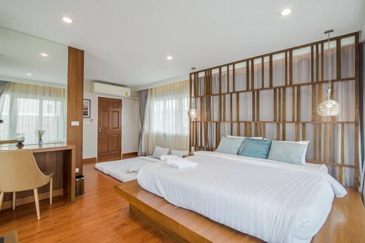 Une chambre d’hôtel moderne dotée d’un grand lit, d’un bureau et d’un coin salon.