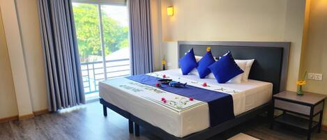 Habitación de hotel Galaxy S22 Ultra con una cama grande, una mesita de noche, una ventana con cortinas y vistas a zonas verdes.