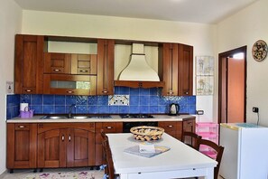 Stovetop, coffee/tea maker, cookware/dishes/utensils, dining tables