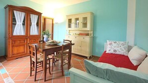 Ett kompakt bostadsutrymme med en matplats, en soffa och två skåp.