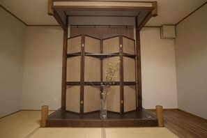 A traditional Japanese room with tatami flooring, a shoji screen, and a vase with flowers. - KIRAKU･NIJO (Kyoto)