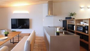 A modern kitchen with a built-in oven, microwave, and stainless steel range hood. - Dannoura Strait Villa (Shimonoseki)