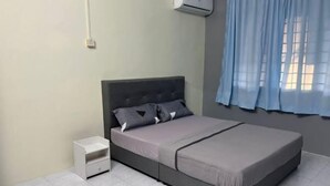 Un dormitorio con cama, mesita de noche y ventana con cortinas.