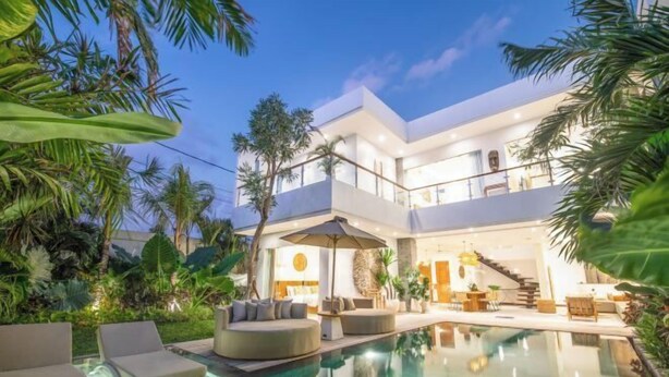 A modern multi-story house with a large outdoor swimming pool, surrounded by lush tropical plants. - sol N1 · Incredible 4 Bds villa near Finns club (Bali)