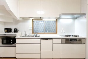 A modern kitchen with white cabinetry, a built-in oven, a gas stove, and a dishwasher. - lami home (Tokyo)