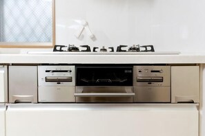 A kitchen with a built-in dishwasher, oven, and microwave. - lami home (Tokyo)