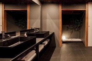 A modern bathroom with two sinks, a mirror, and a small plant. - KEYAKIZAKA (Ito)