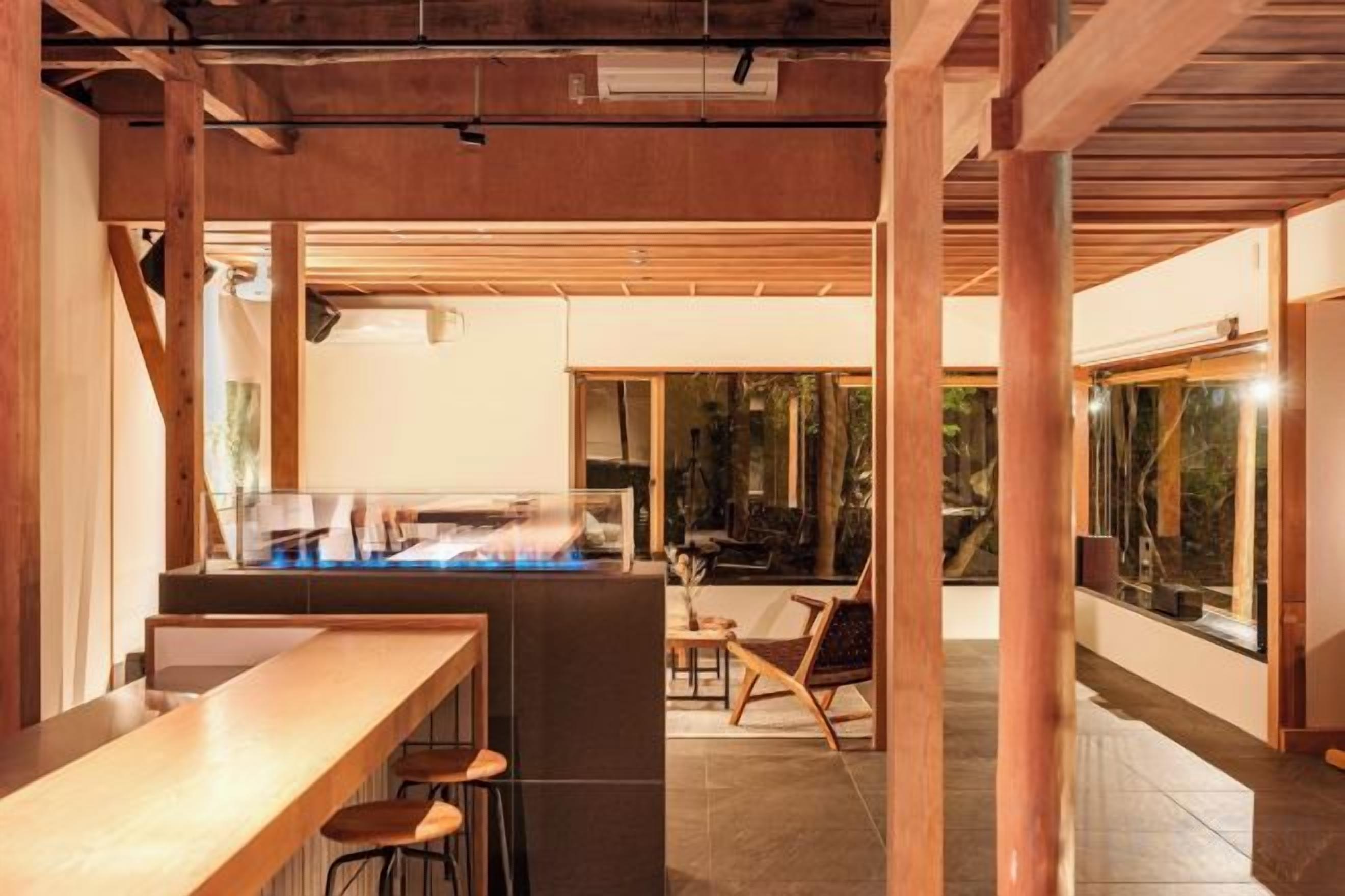 A bar area with stools, a counter, and a view of the outdoors.