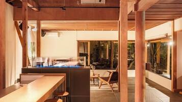 A bar area with stools, a counter, and a view of the outdoors.