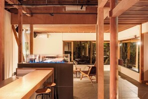 A bar area with stools, a counter, and a view of the outdoors. - KEYAKIZAKA (Ito)