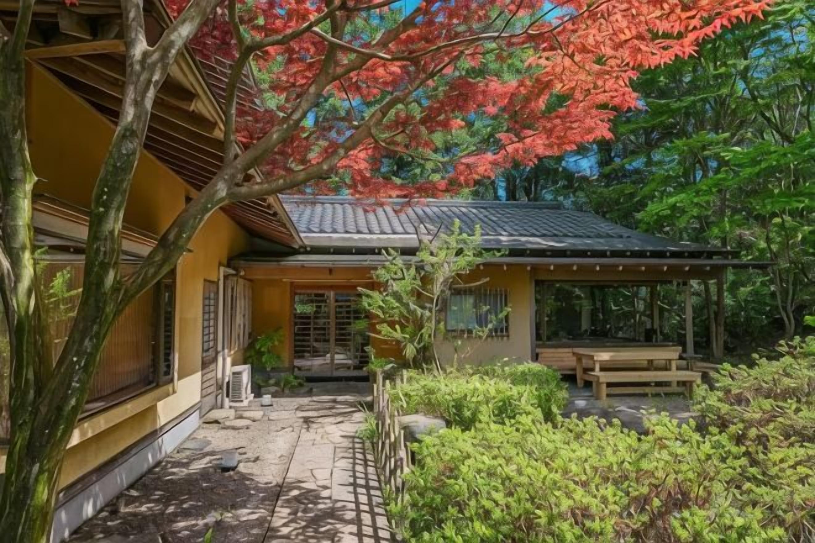 A traditional Japanese building with a covered patio, a wooden bench, and a stone pathway.