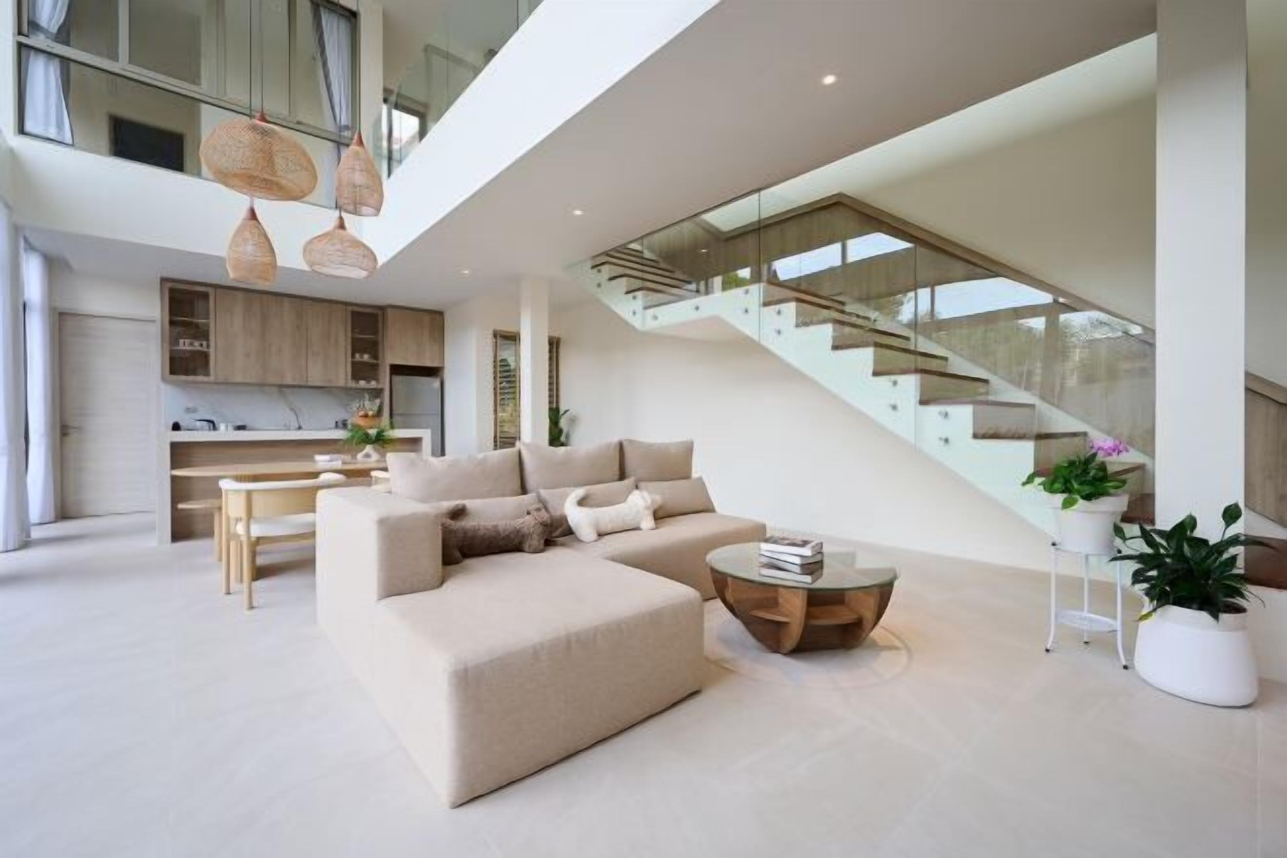 A modern living room with a sofa, coffee table, and staircase.