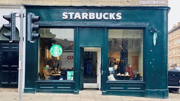 Een Starbucks aan Nicolson Street, herkenbaar aan de groene gevel en grote ramen.