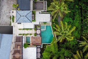 A resort with a pool, outdoor seating, and lush greenery. - Villa Oasis by BaliSuperHost (Bali)
