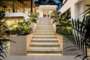 A staircase leading to a modern building with plants on either side. - Villa Oasis by BaliSuperHost (Bali)