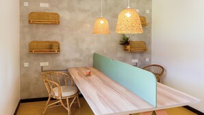 A room with a wooden table, two wicker chairs, a light blue partition, and hanging wicker lamps. - Samba Ahangama (Ahangama)
